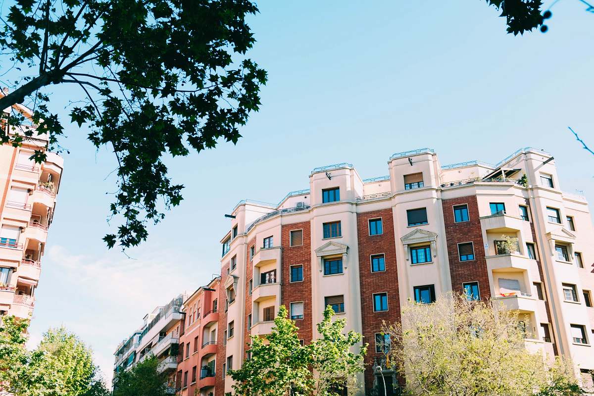 building white and brown concrete buildings near tree at daytime high rise