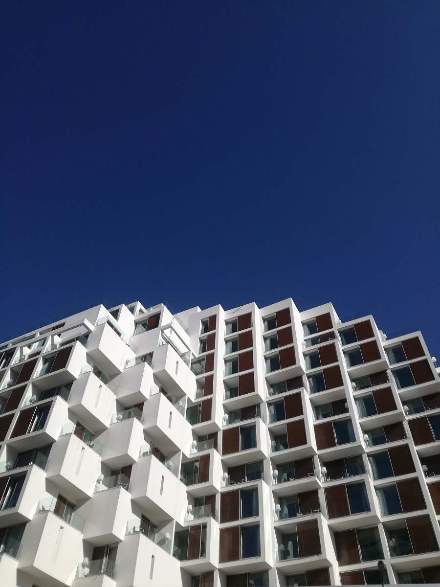 building white concrete building under blue sky during daytime high rise