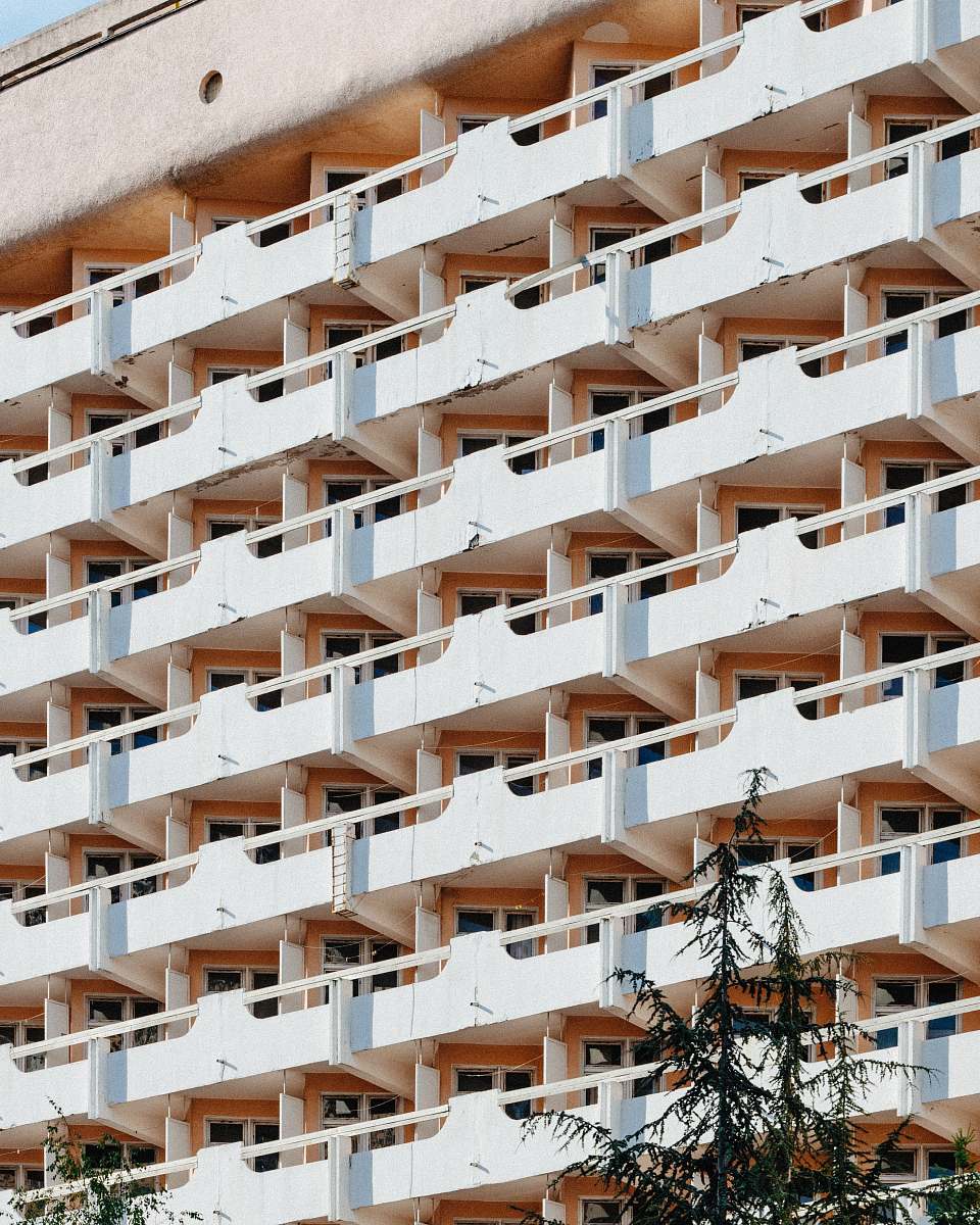 building white concrete high-rise building over the trees high rise