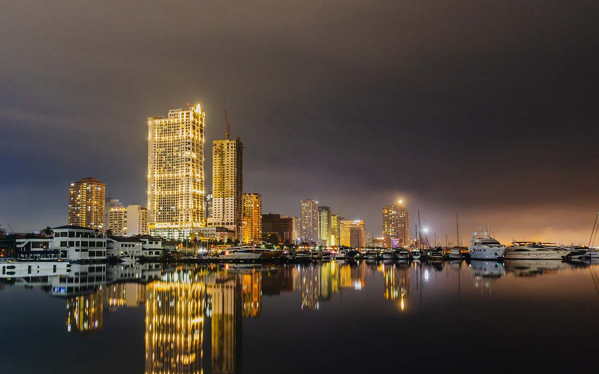urban yellow lighted buildings by the harbor under grey cloudy sky building