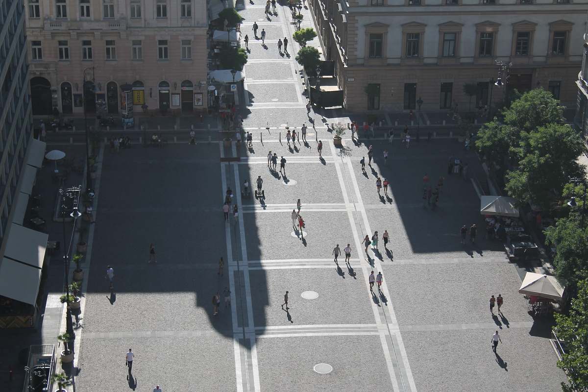 intersection group of people walking on the road surrounded by buildings road