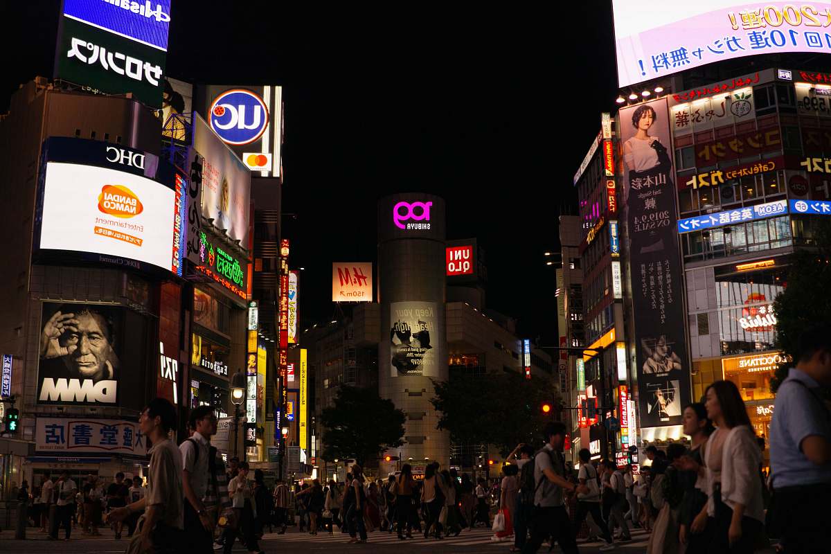 pedestrian crowd of people walking beside buildings during nightime person
