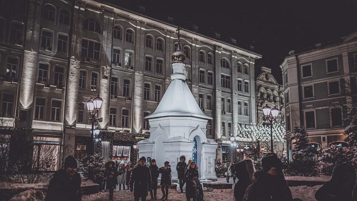 pedestrian people walking outside near white dome building during nighttime person