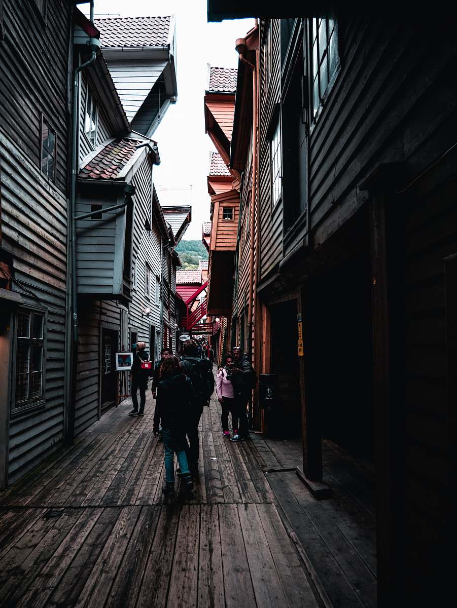 street people walking on narrow pathway during daytime town