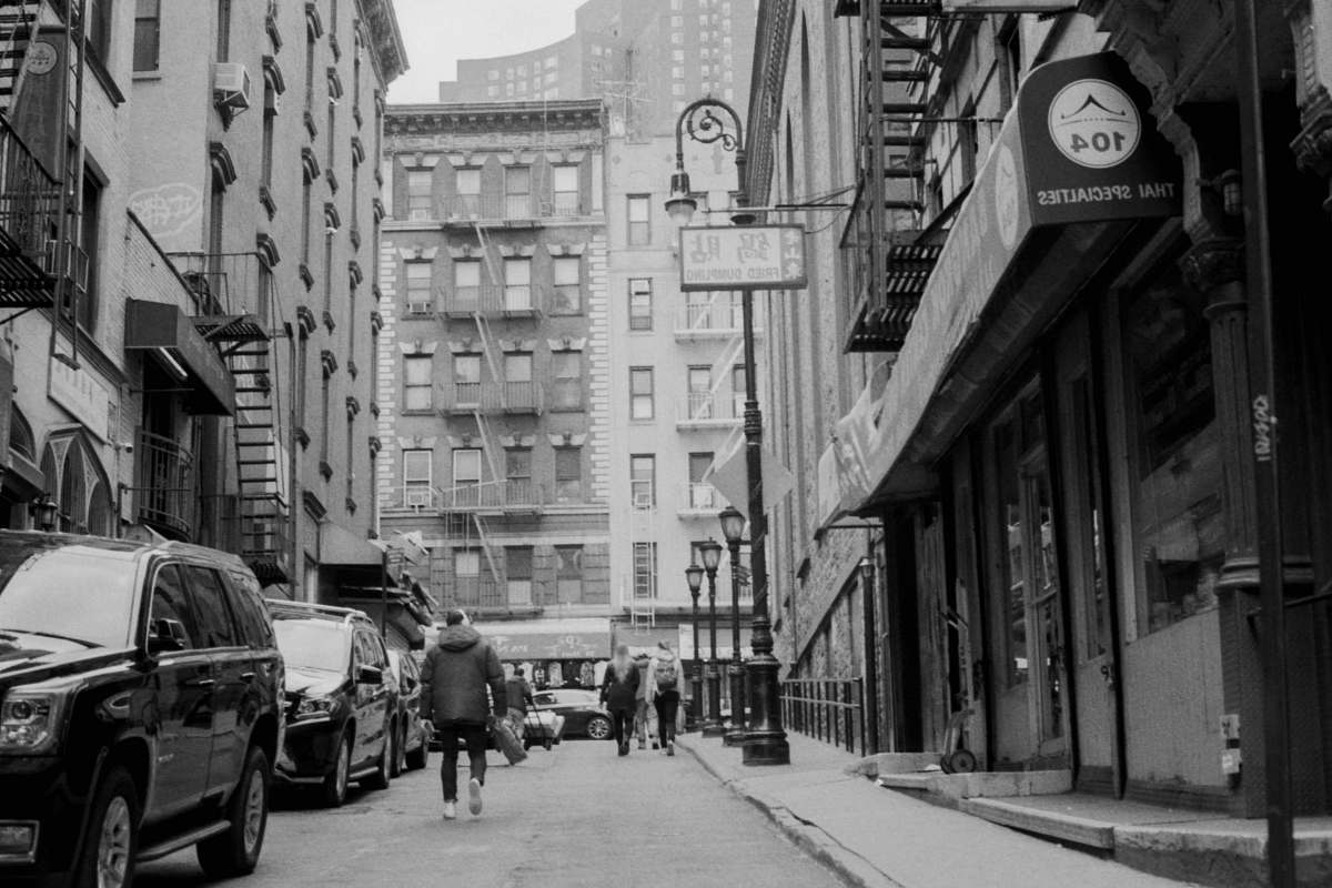 town grayscale photography of road with buildings black-and-white