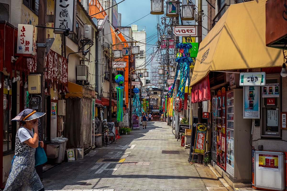 building woman crossing the alley between stores during daytime street