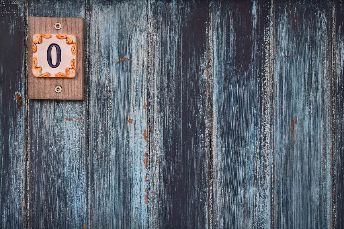 texture A weathered wooden wall with a small plaque with the number zero wood