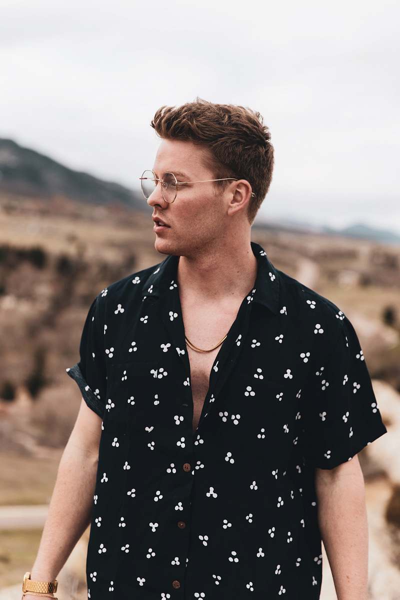 person man in black and white polka dot button up shirt wearing eyeglasses apparel