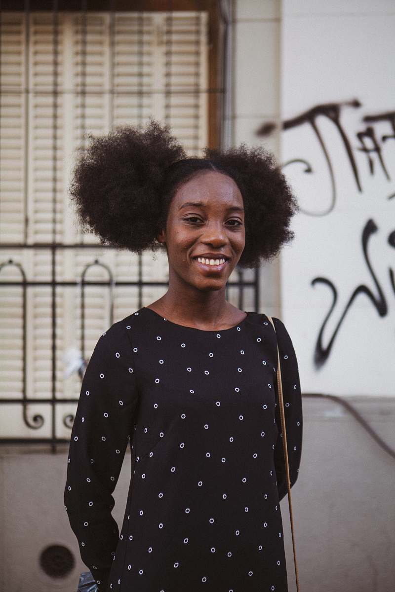 person man in black and white polka dot crew neck long sleeve shirt standing beside white wall hair