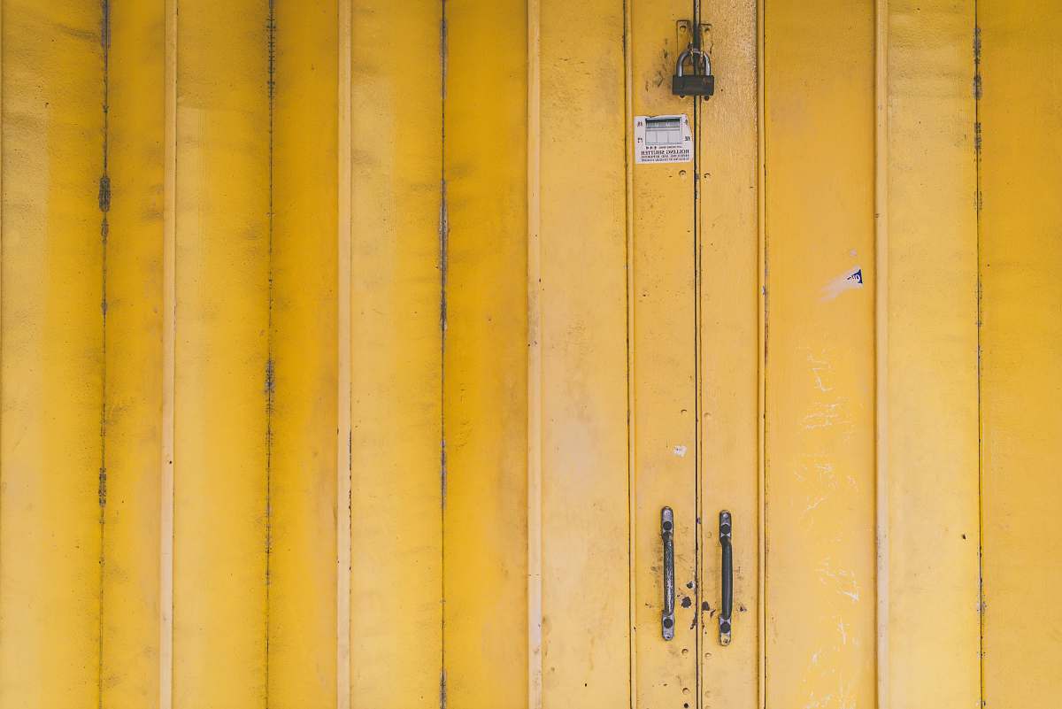 background closed yellow wooden door with padlock yellow