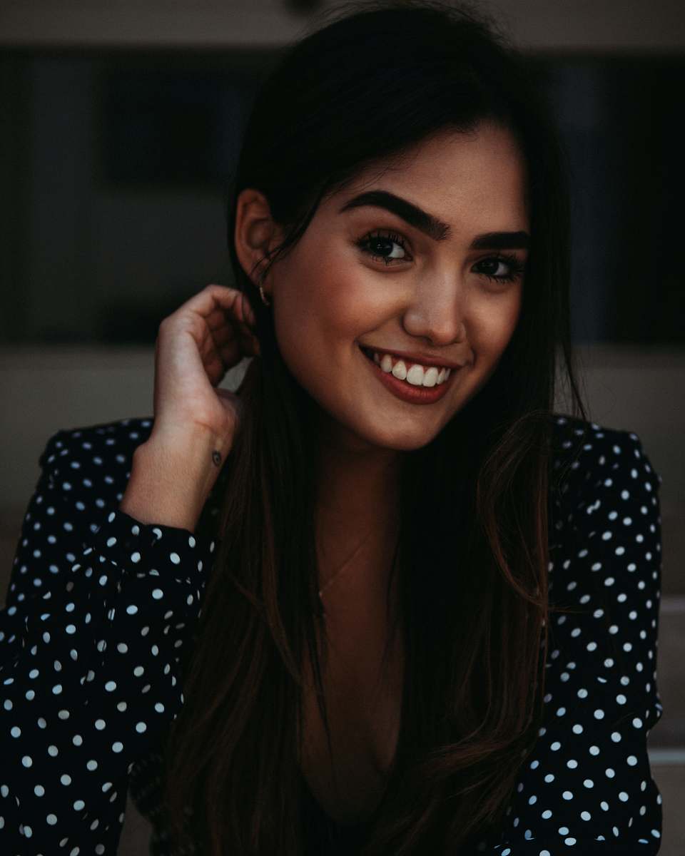 human shallow focus photo of woman in black and white polka-dot long-sleeved shirt person