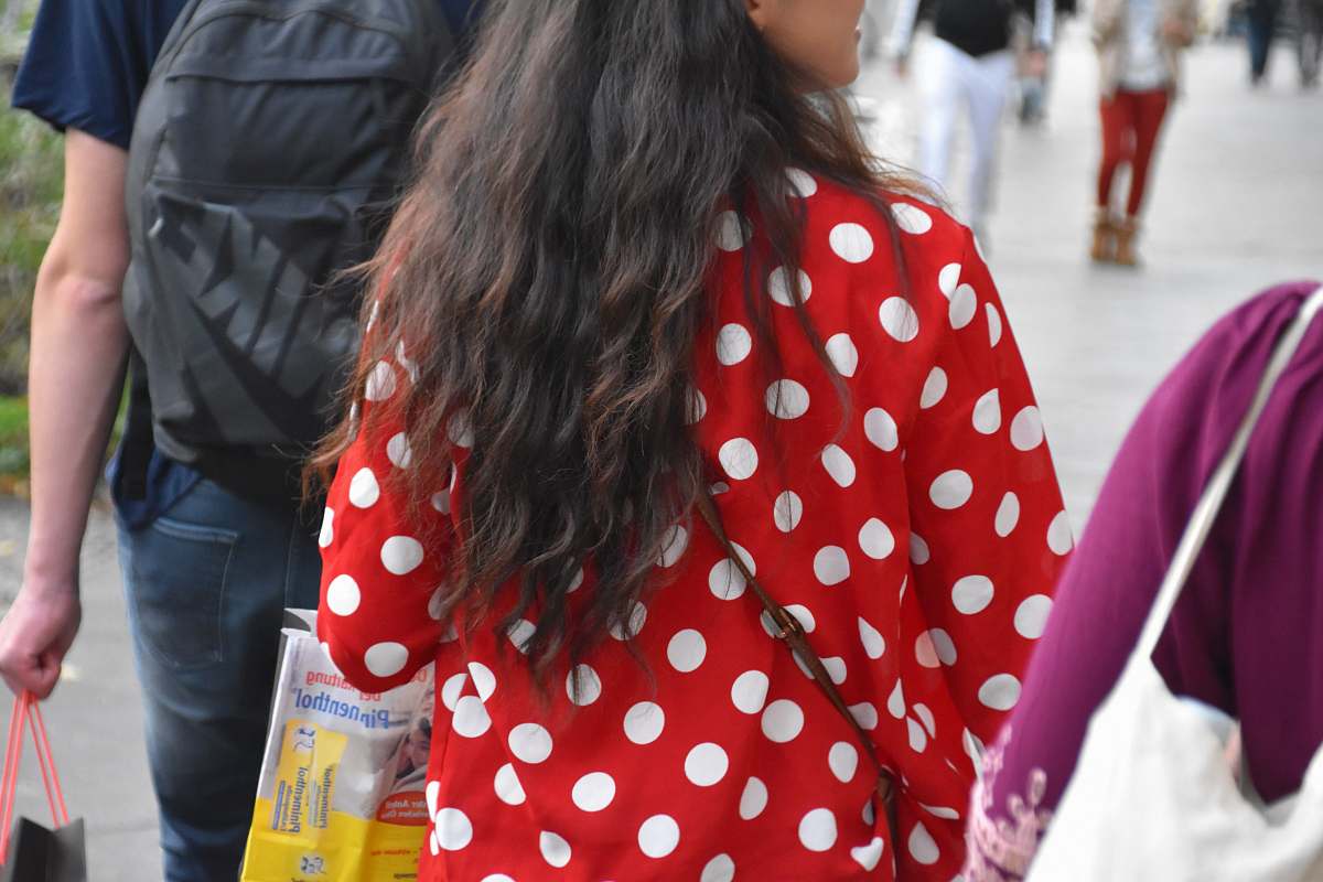 person woman in red and white polka dot long sleeve shirt holding plastic bottle human
