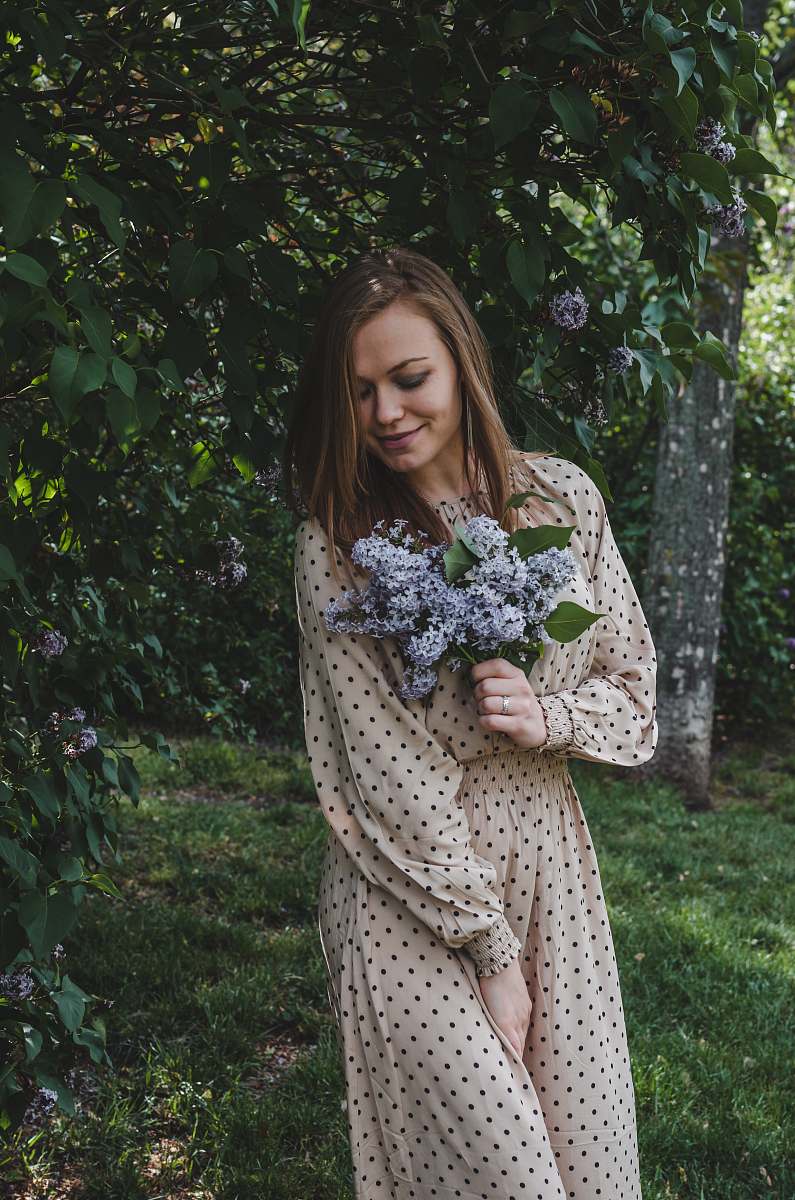 apparel woman in white and black polka dot dress standing on green grass field clothing