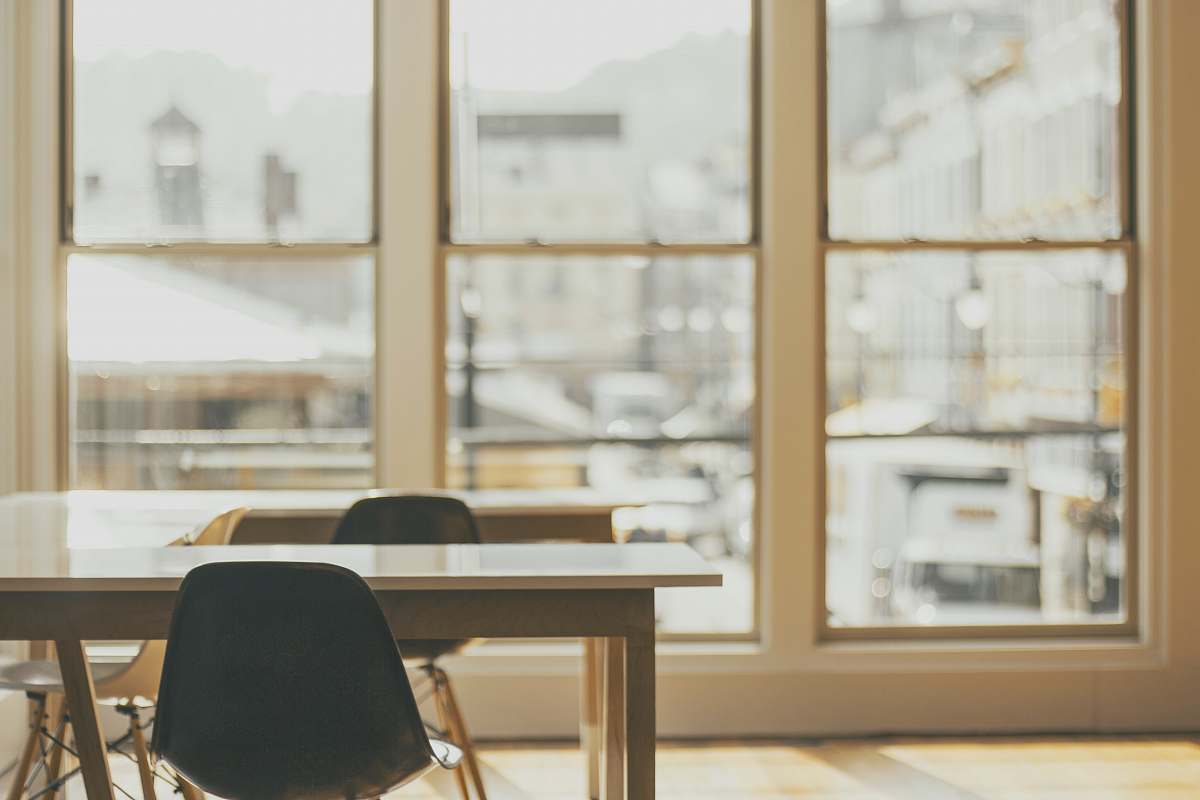  two white wooden tables near glass window 