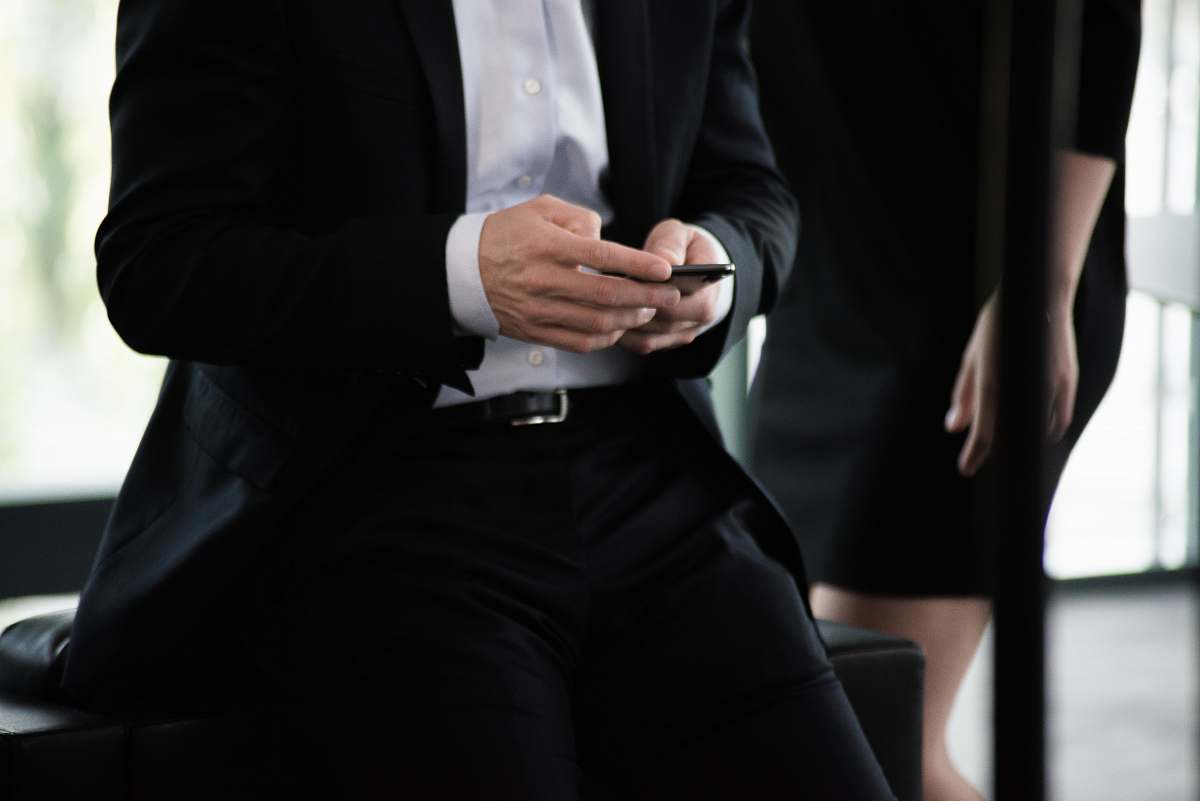clothing man in black suit with phone in hand suit