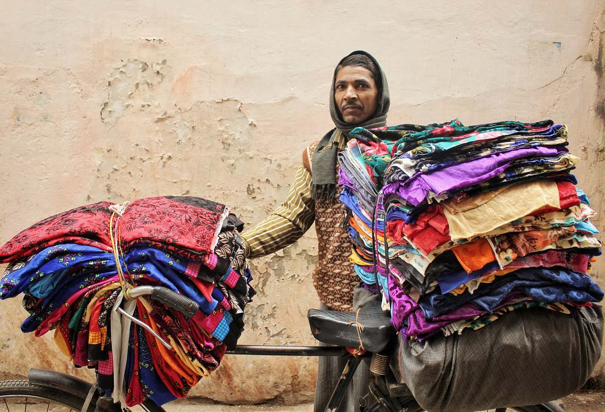 varanasi man standing beside bicycle with clothes india