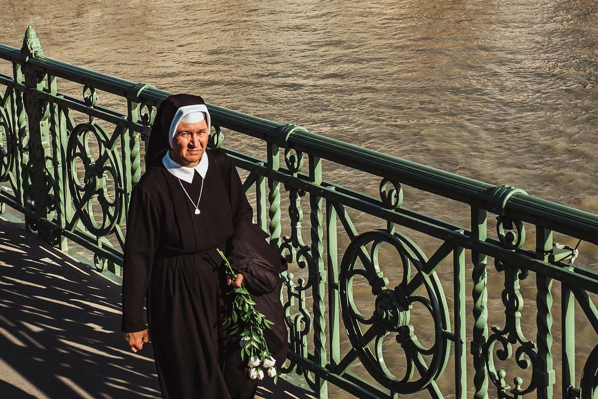clothing nun walking near the ocean railing