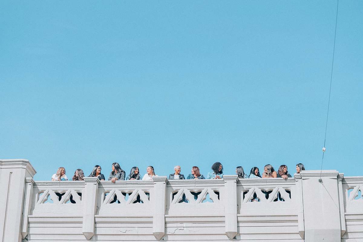 Capture the essence of love and celebration with this stunning image of a bride and groom standing gracefully in front of a handrail on a rooftop. The breathtaking backdrop highlights the couple's intimate moment, making it perfect for wedding invitations, romantic blog posts, or any project that celebrates love and commitment. This enchanting scene is ideal for photographers, event planners, and marketers looking to convey elegance and romance in their visual storytelling.