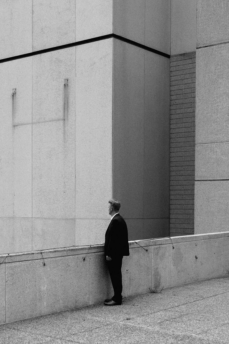 wall greyscale photo of man standing on bridge during daytime grey