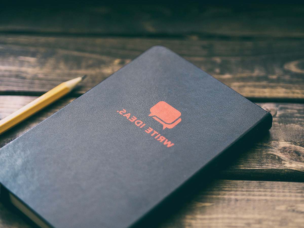 writing Write Ideas book on brown wooden board paper