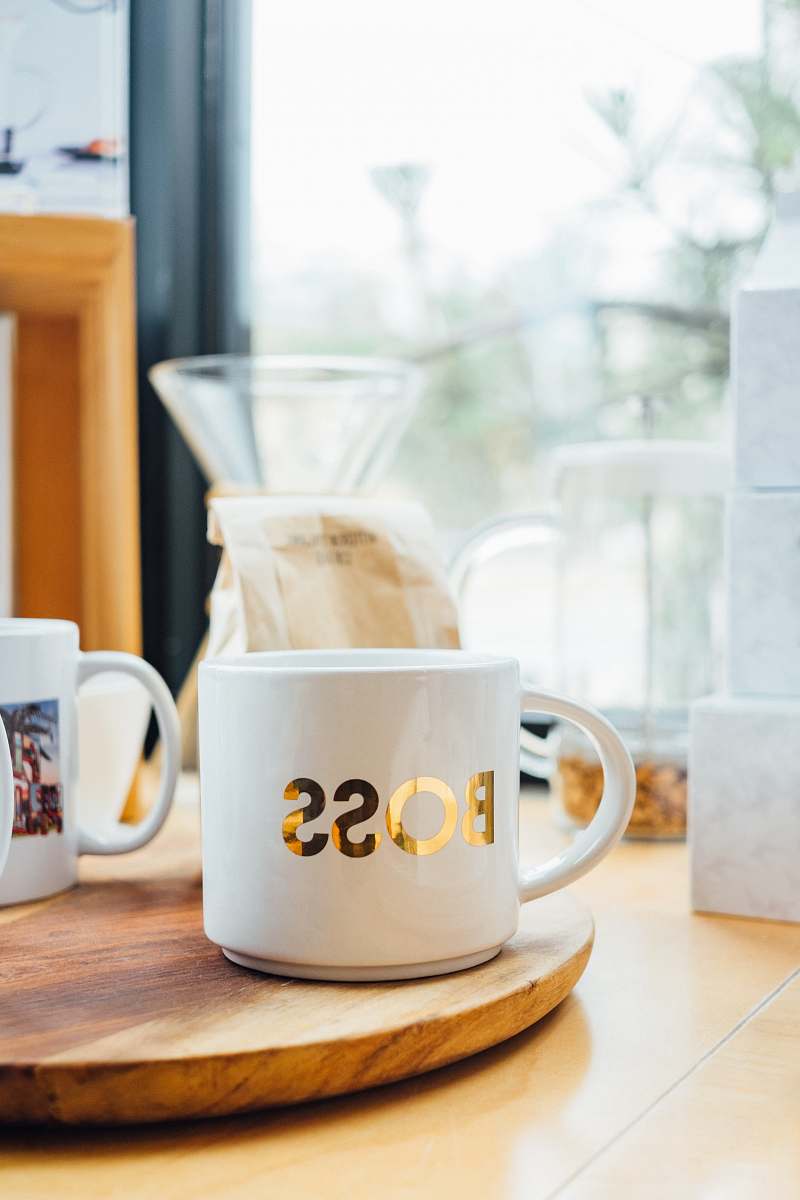 cup white Boss-printed ceramic mug on brown surface coffee cup