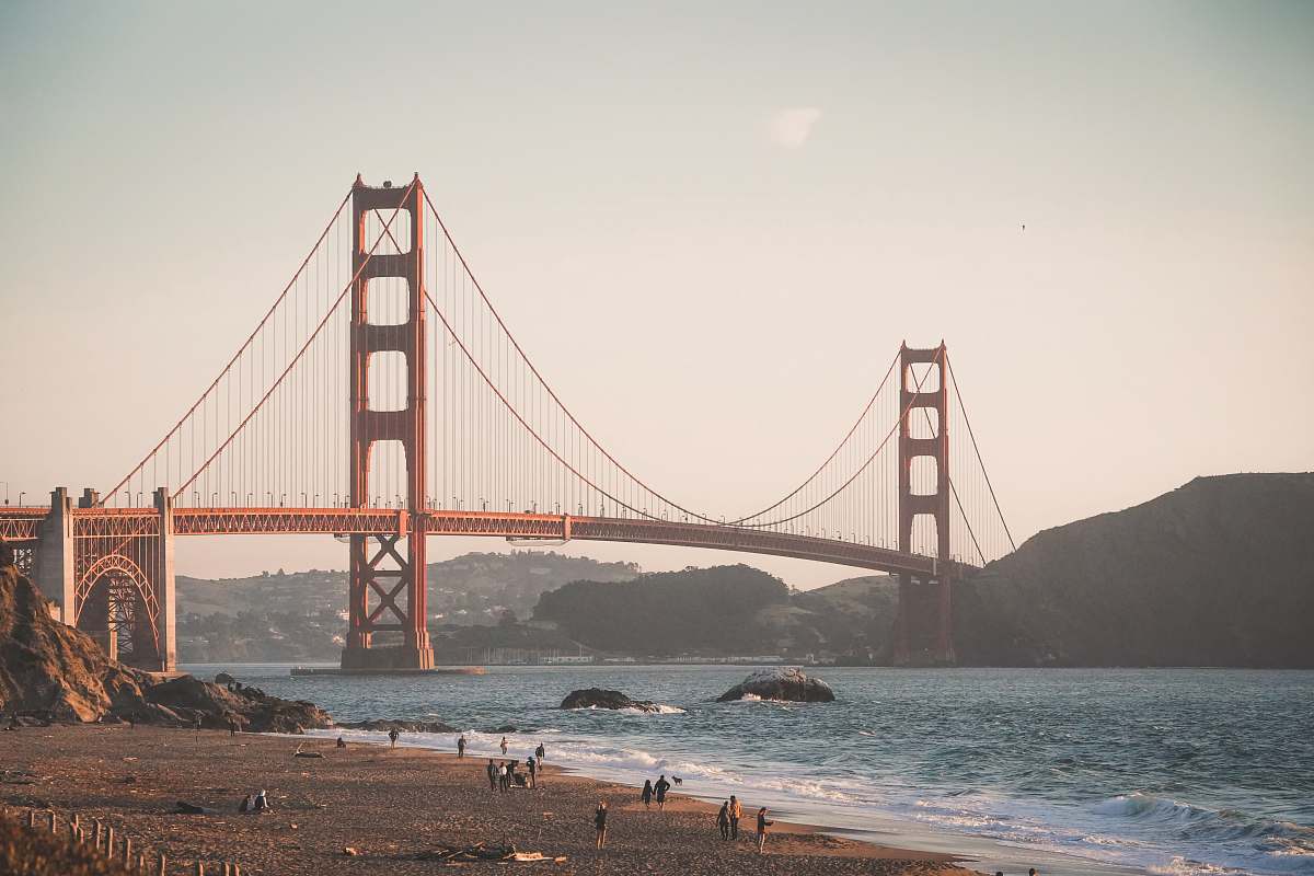 building people walking near red bridge on body of water during daytime photo san francisco