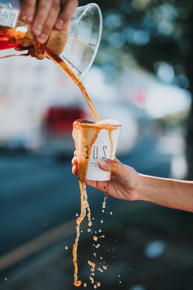 coffee person holding white ZOE brand paper cup drink