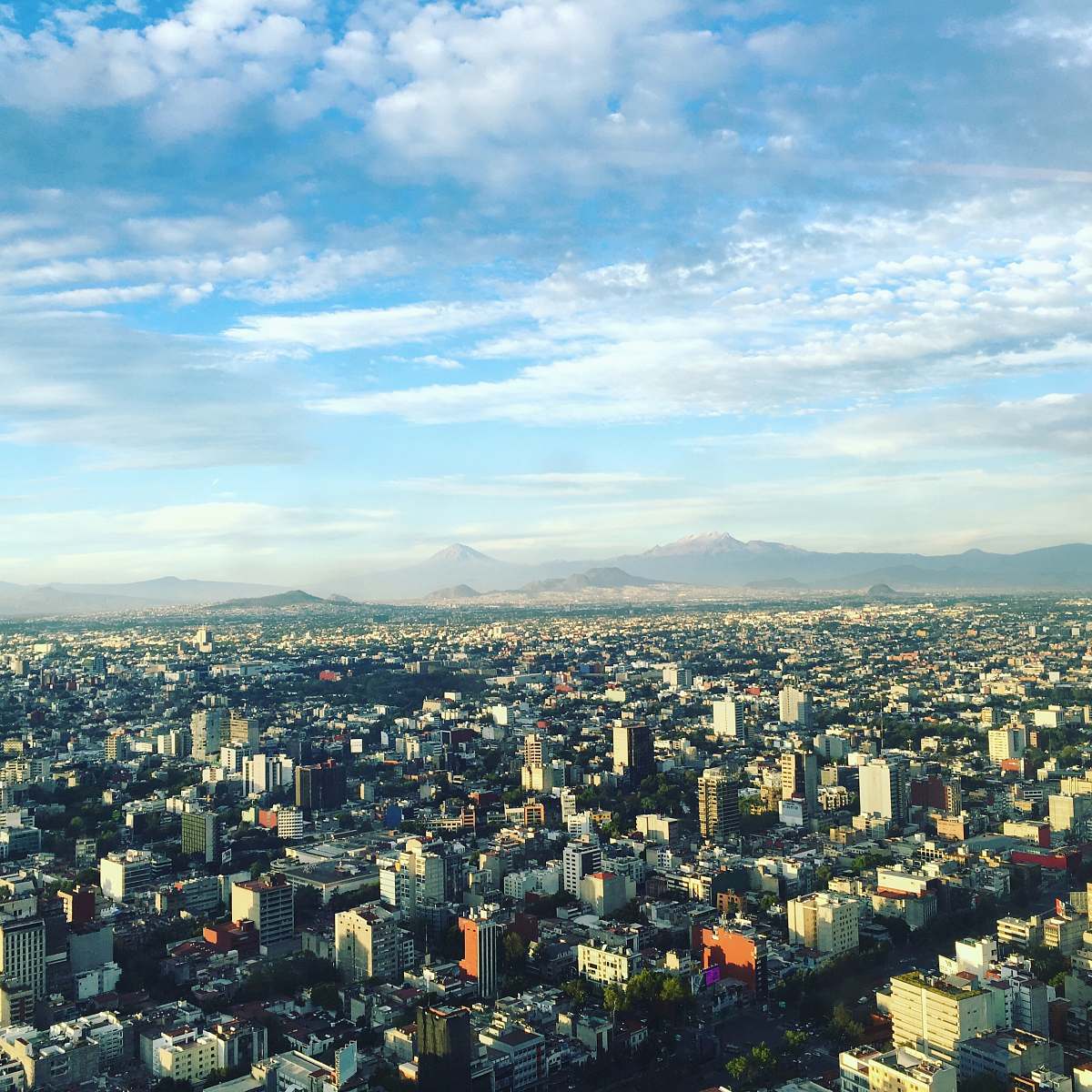 city aerial photo of concrete buildings under white clouds at daytime urban
