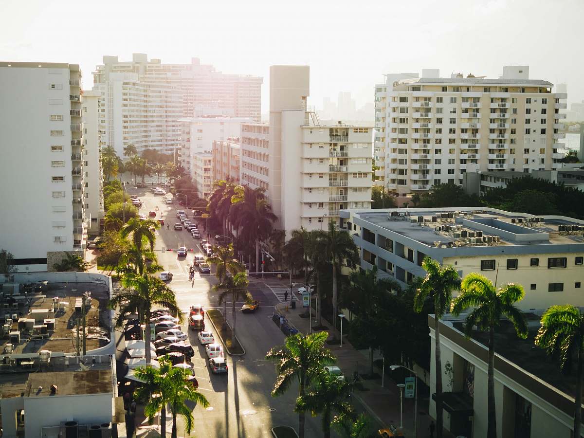 city aerial view of vehicle passing between building during daytime flora
