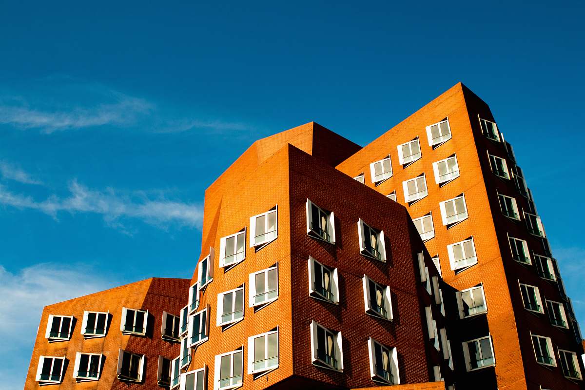 condo brown concrete building under cloudy sky housing
