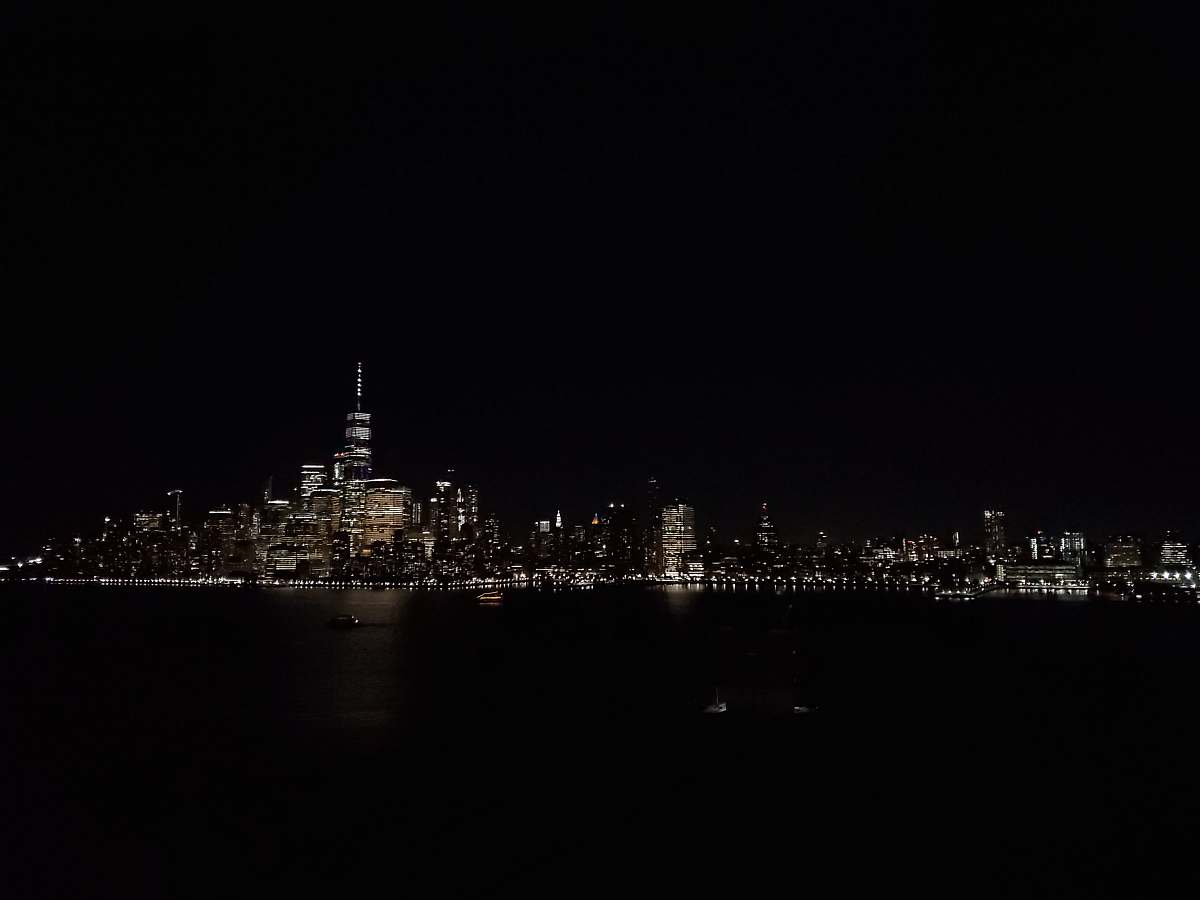 city buildings near ocean during nighttime metropolis