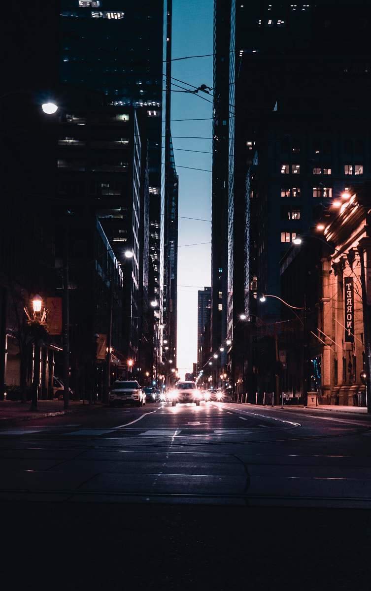 urban cars with headlights on traveling on street road