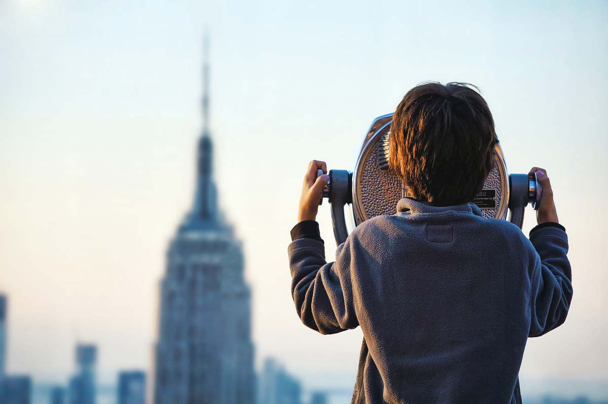 city child looking at Empire State building through tower viewer people