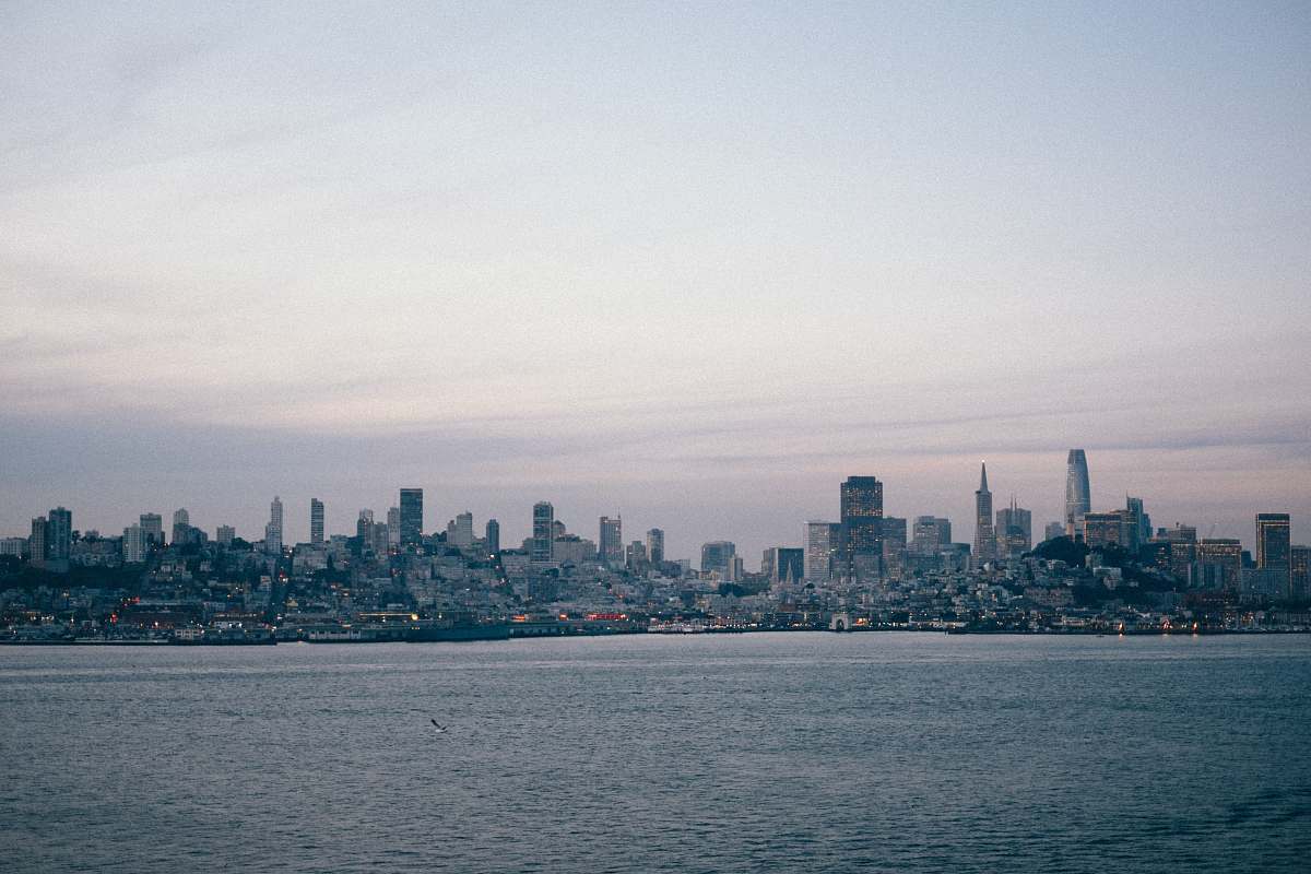 urban city skyline near calm sea water during daytime grey