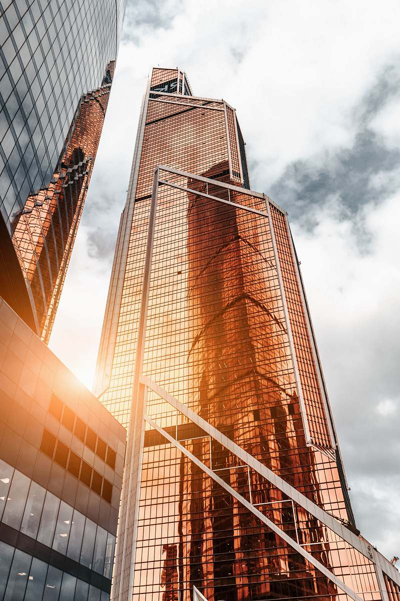 city gold high-rise building under cloudy sky urban