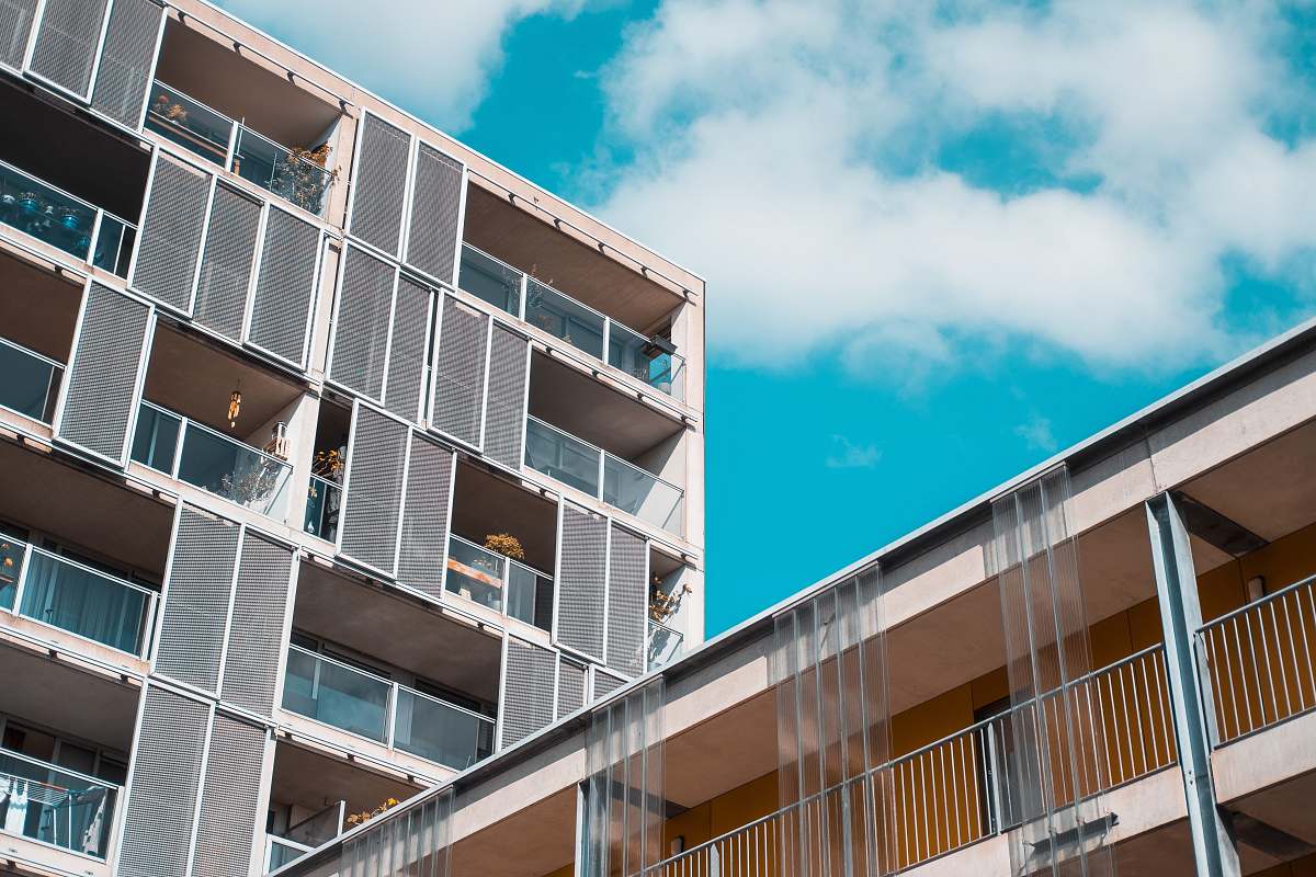 city gray concrete building under cloudy sky high rise
