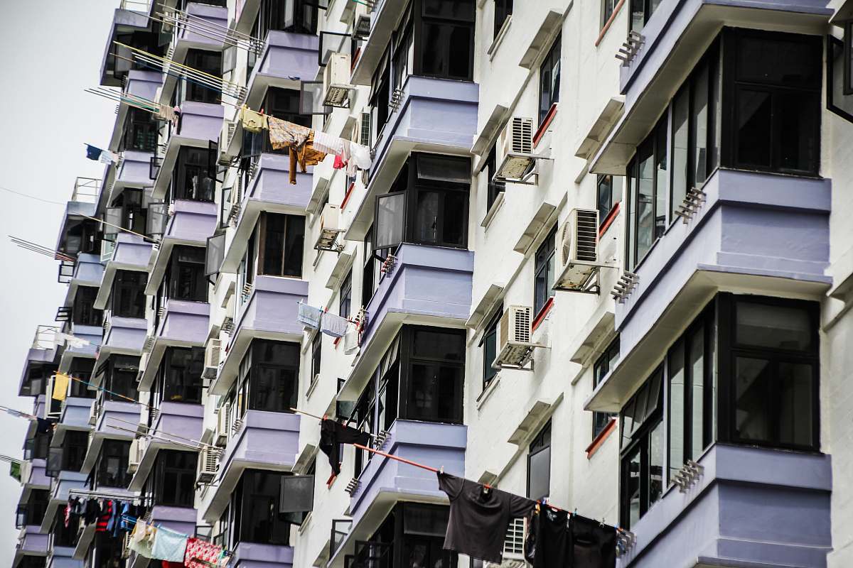 city hanged clothes on building terraces with poles during daytime home decor