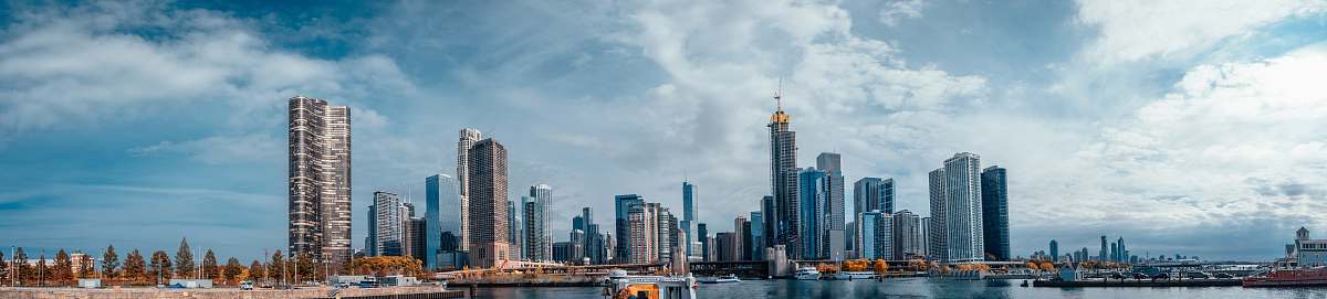 city high rise buildings near body of water under cloudy sky at daytime high rise