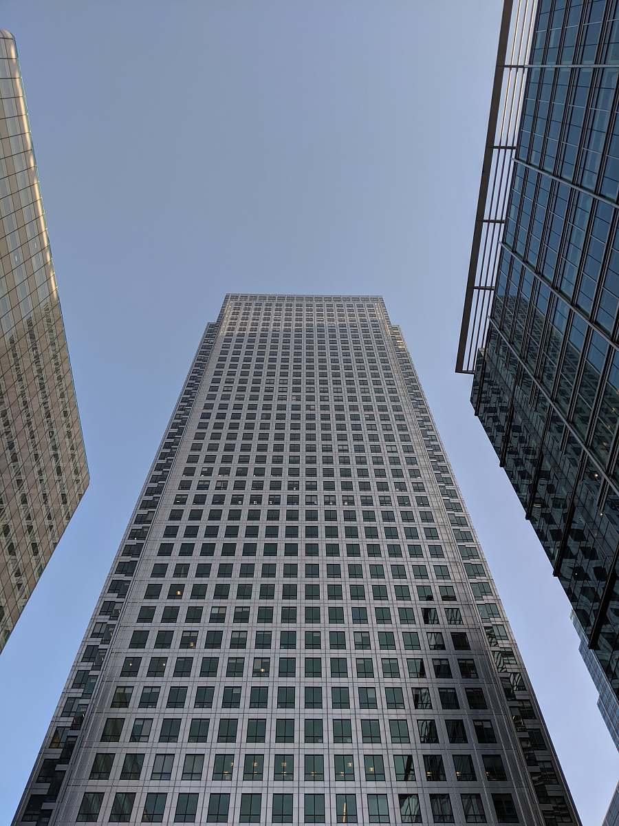 urban low-angle photography of white glass building under calm blue sky office building