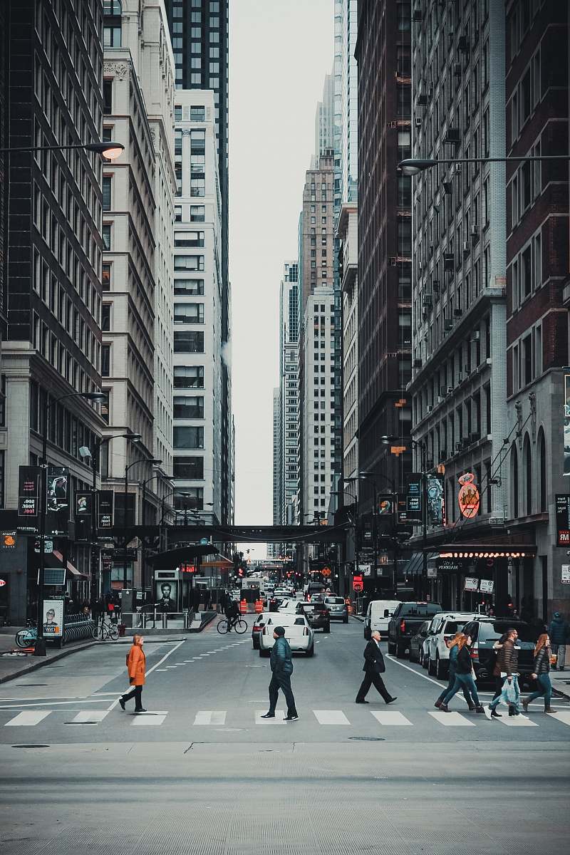 city people crossing on gray asphalt road in the city during daytime road
