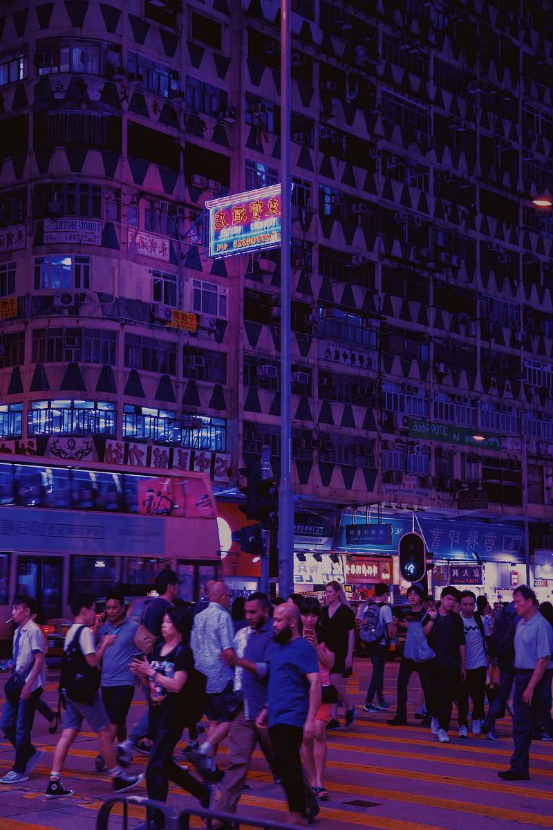 city people standing beside concrete buildings during night time downtown