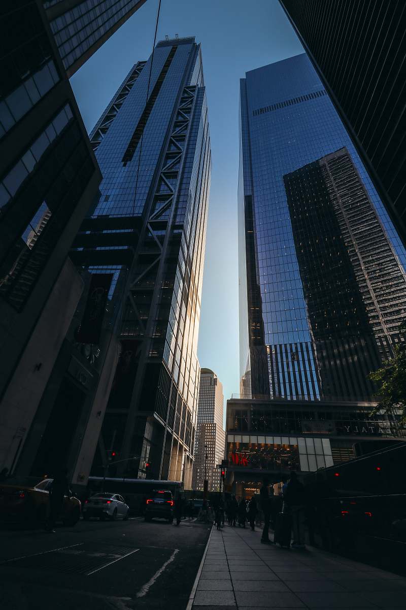 city people walking on the side walk during daytime high rise