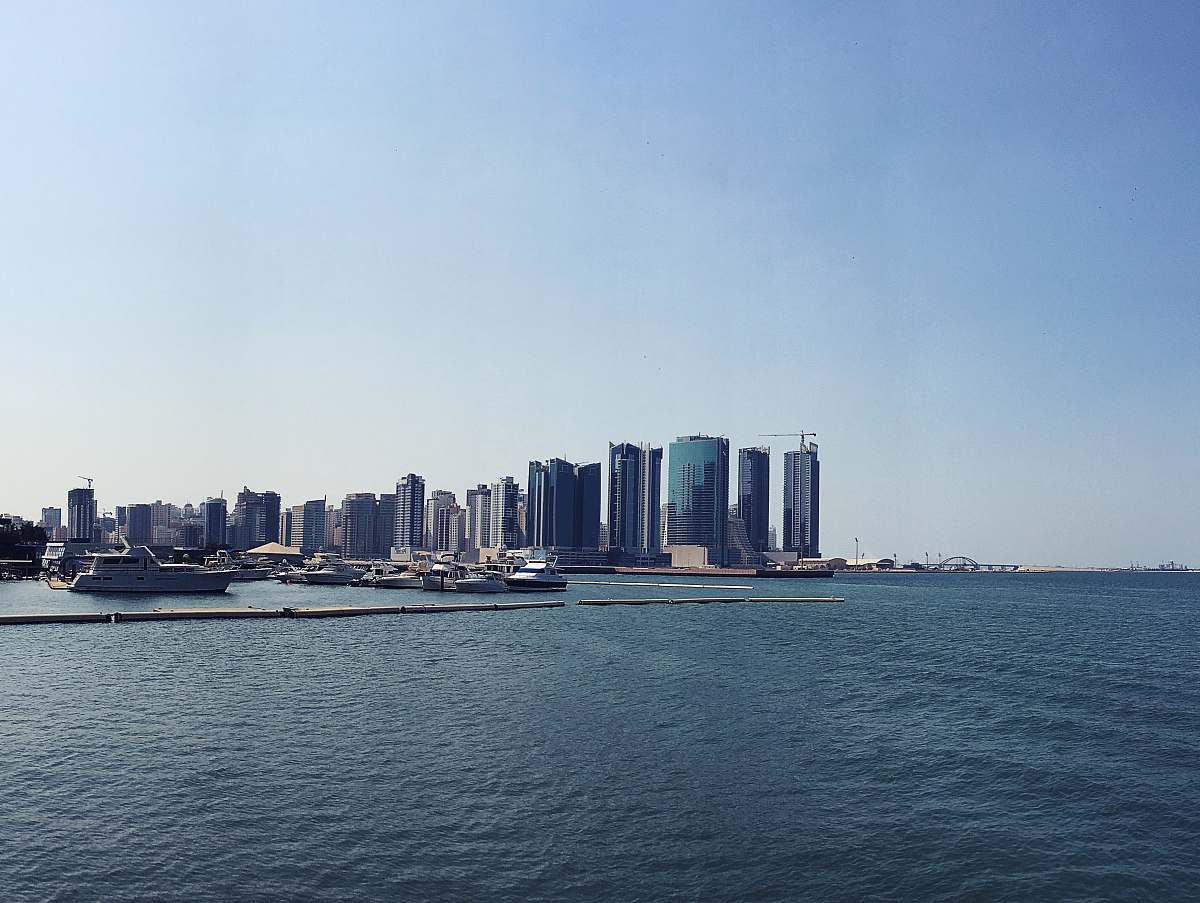 city photography of high-rise building beside seashore during daytime metropolis
