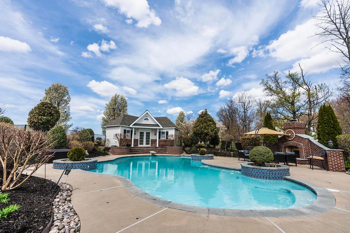 water swimming pool with parasol, tables, and chairs pool