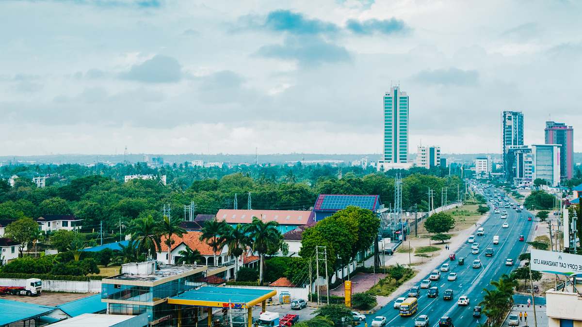 city vehicle passing on road between small buildings during daytime metropolis