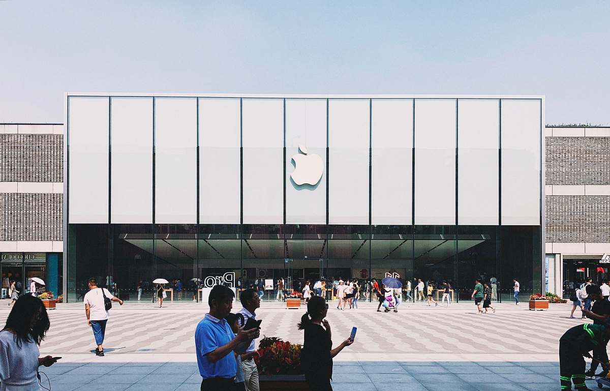 human white Apple building under blue sky person