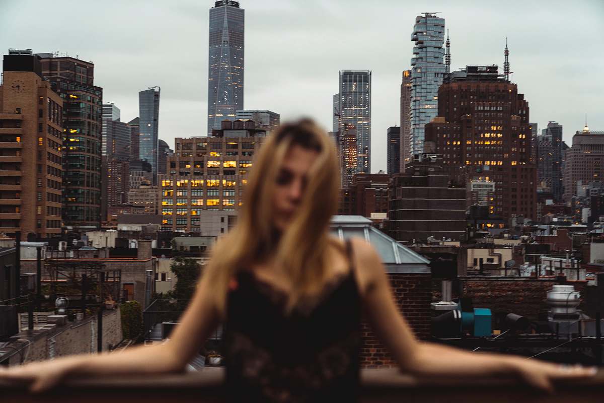 city woman wearing black spaghetti-strap top in front of city town