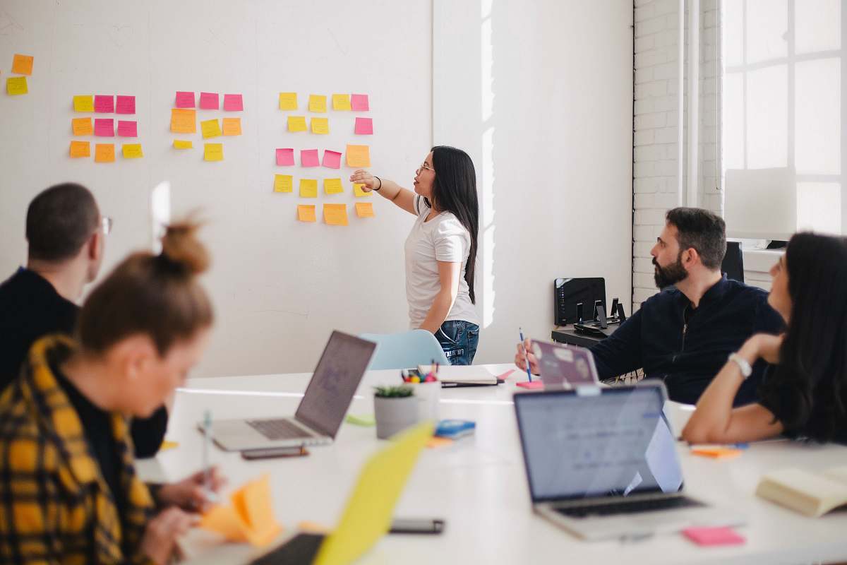 human woman placing sticky notes on wall person