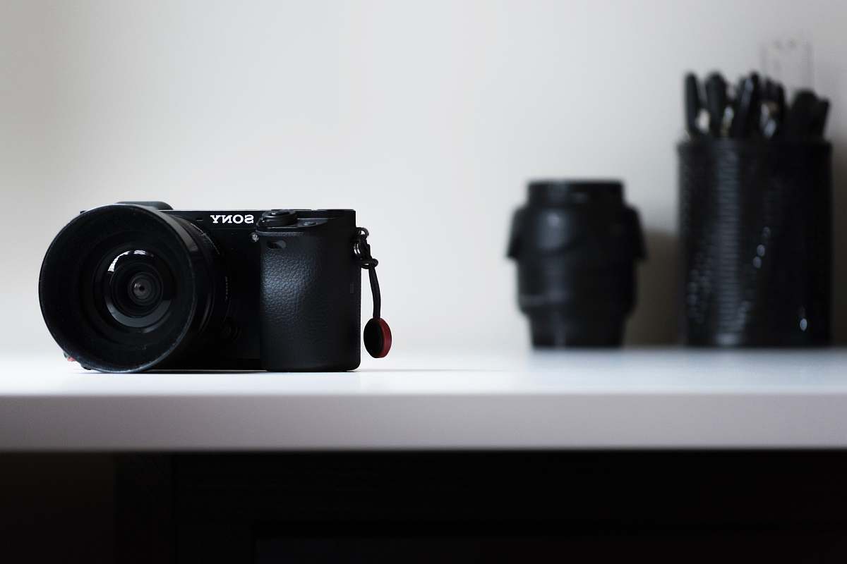 electronics black Sony DSLR camera on white desk sony