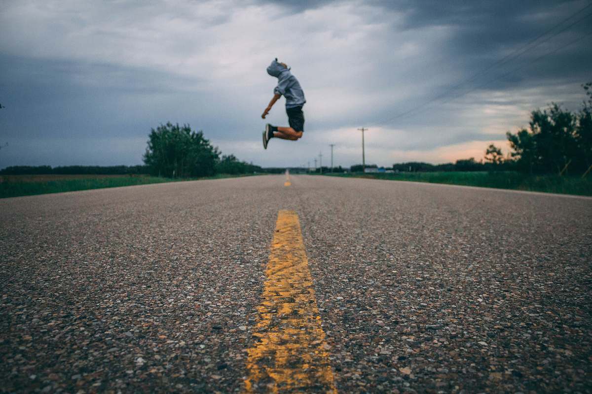 road time-lapse photo of person jumping at the middle of the road lac santé